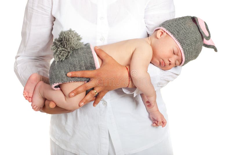 De slaapbaby van de moederholding in konijntjeskostuum stock fotografie De slaapbaby van de moederholding in konijntjeskostuum stock fotografie