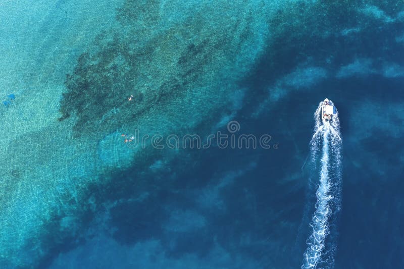De snelheidsboot dichtbij vader en zoon snorkelt door tropische, turkooise wateren, satellietbeeld royalty-vrije stock foto's De snelheidsboot dichtbij vader en zoon snorkelt door tropische, turkooise wateren, satellietbeeld royalty-vrije stock foto's