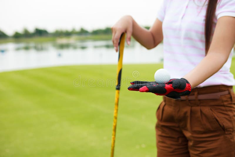 De speler die van het golf de golfclub van de golfbalholding toont royalty-vrije stock afbeelding De speler die van het golf de golfclub van de golfbalholding toont royalty-vrije stock afbeelding