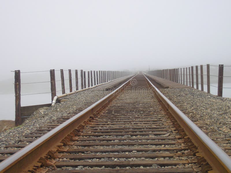 De sporen van de spoorweg in mist stock afbeelding De sporen van de spoorweg in mist stock afbeelding