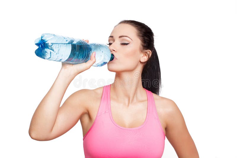 De sportieve donkerbruine vrouw drinkt water