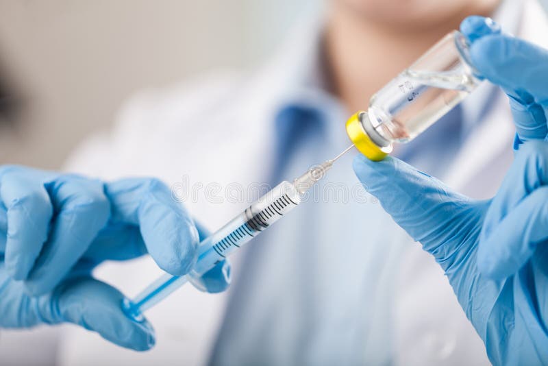 De spuit en het vaccin van de handholding stock afbeelding De spuit en het vaccin van de handholding stock afbeelding