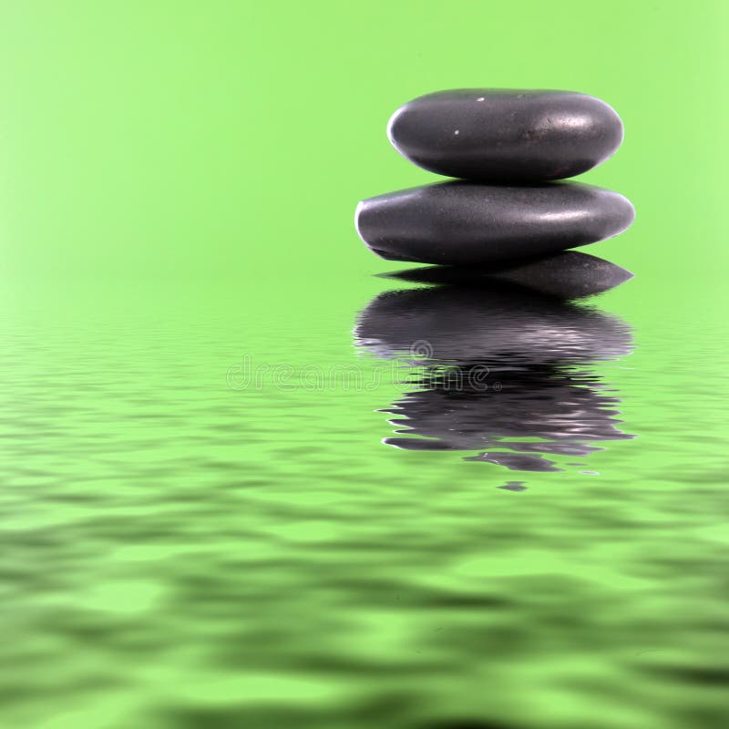 De stenen van de kuuroordmassage in groen water royalty-vrije stock foto De stenen van de kuuroordmassage in groen water royalty-vrije stock foto