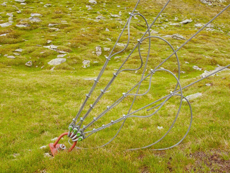 De sterke slinger en het schroot in groene werf, ijzer verdraaiden kabel vast door schroeven onverwachte haken en dichtingsringen royalty-vrije stock fotografie De sterke slinger en het schroot in groene werf, ijzer verdraaiden kabel vast door schroeven onverwachte haken en dichtingsringen royalty-vrije stock fotografie