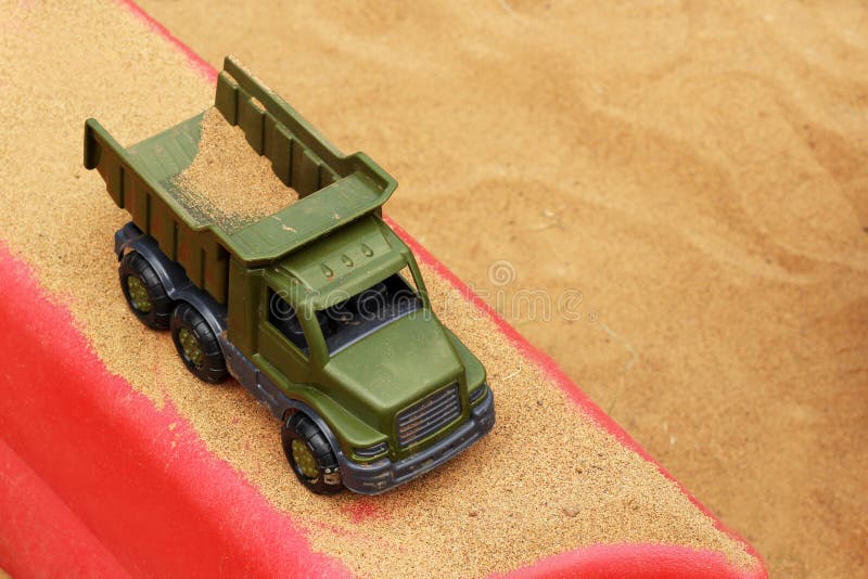 De stortplaatsvrachtwagen maakt grond op het zand bij een bouwwerf leeg royalty-vrije stock afbeelding De stortplaatsvrachtwagen maakt grond op het zand bij een bouwwerf leeg royalty-vrije stock afbeelding