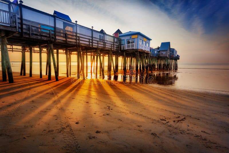 Old Orchard Beach pier with rays through the pilings at low tide. Old Orchard Beach pier with rays through the pilings at low tide