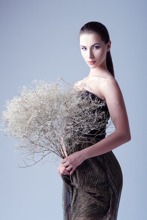 De studiomanier schoot: mooie jonge vrouw in het boeket van de kledingsholding van vernietigde bloemen royalty-vrije stock foto's De studiomanier schoot: mooie jonge vrouw in het boeket van de kledingsholding van vernietigde bloemen royalty-vrije stock foto's