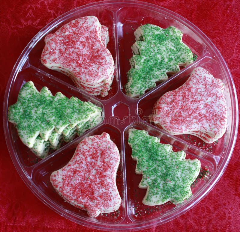 Christmas cookies in shapes of christmas trees and jingle bells in a plastic party tray. Christmas cookies in shapes of christmas trees and jingle bells in a plastic party tray