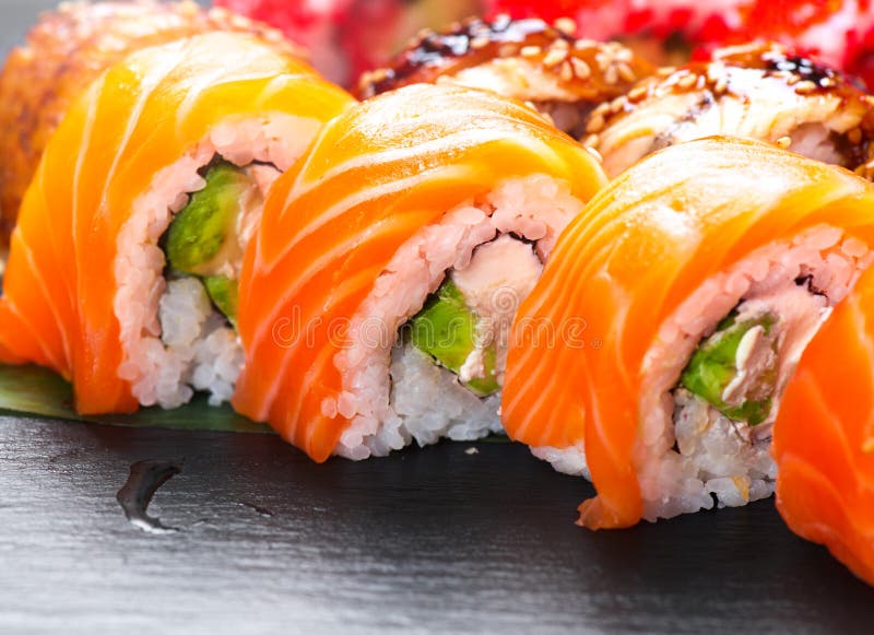 De sushi rolt close-up Japans voedsel in restaurant Broodje met zalm, paling, groenten en vliegende vissenkaviaar royalty-vrije stock afbeelding De sushi rolt close-up Japans voedsel in restaurant Broodje met zalm, paling, groenten en vliegende vissenkaviaar royalty-vrije stock afbeelding