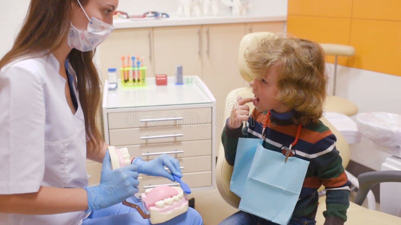 De tandarts vertelt het kind over mondelinge hygiëne