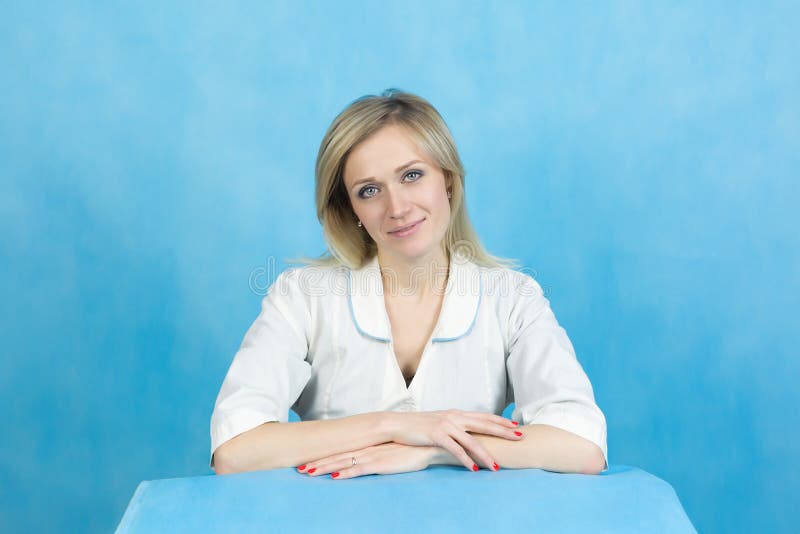 De technicus van het meisjeslaboratorium op een blauwe achtergrond stock fotografie De technicus van het meisjeslaboratorium op een blauwe achtergrond stock fotografie