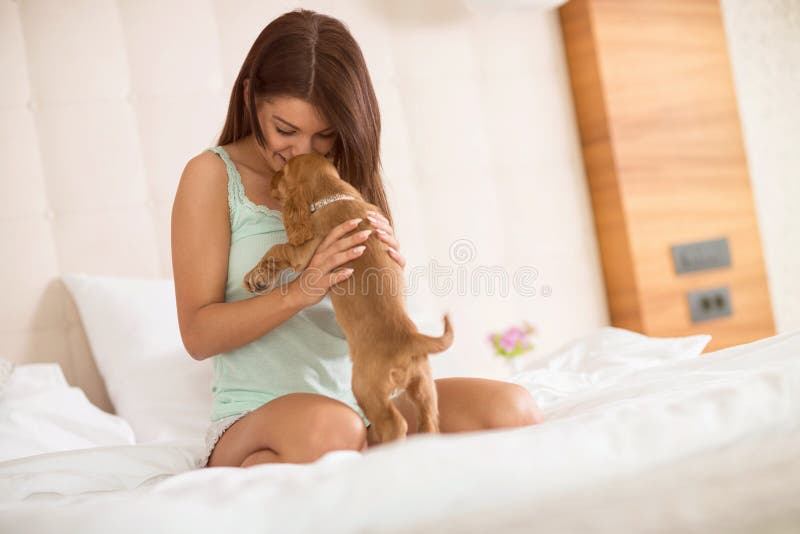 Een meisje deelt tederheid met haar knuffelhondje in bed royalty-vrije stock fotografie