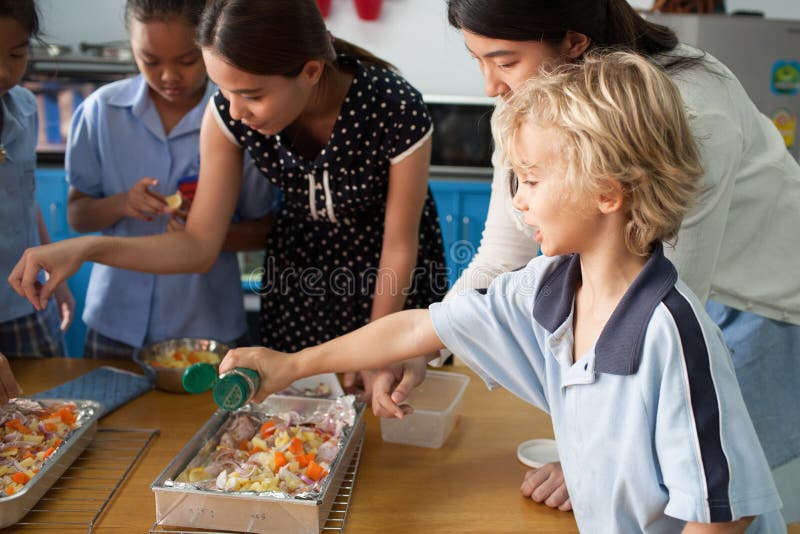 De Thaise jonge schoolkinderen nemen een kokende klasse royalty-vrije stock fotografie De Thaise jonge schoolkinderen nemen een kokende klasse royalty-vrije stock fotografie