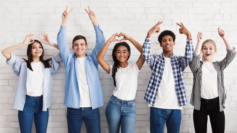 De tienervrienden die gesturing met overhandigt witte muur stock afbeelding De tienervrienden die gesturing met overhandigt witte muur stock afbeelding