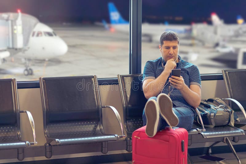 De toerist die van de middenleeftijdsmens smartphone in luchthaventerminal met behulp van die vlucht vertraagde programma's bekij royalty-vrije stock fotografie De toerist die van de middenleeftijdsmens smartphone in luchthaventerminal met behulp van die vlucht vertraagde programma's bekij royalty-vrije stock fotografie