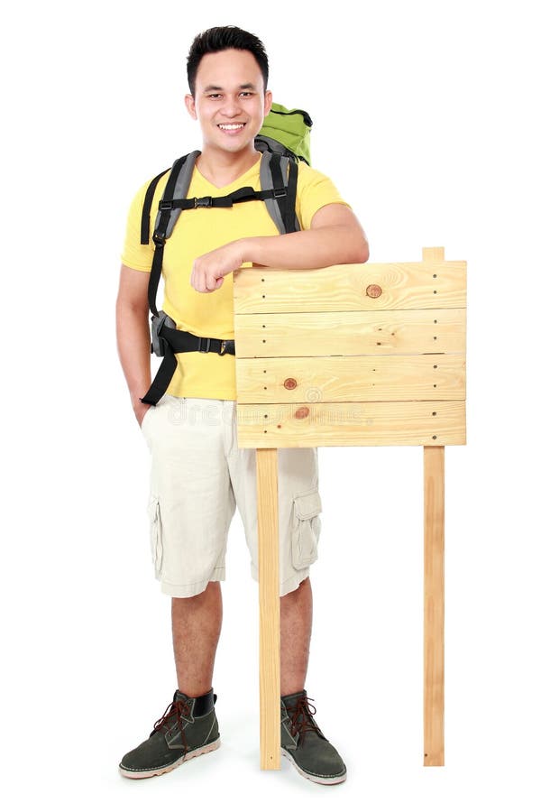 De toerist van de wandelaarmens met leeg houten teken stock afbeelding De toerist van de wandelaarmens met leeg houten teken stock afbeelding