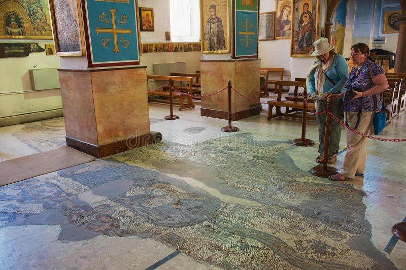 De toeristen bezoeken Byzantijnse Orthodoxe Basiliek van St George met de mozaïekkaart van Heilig Land in Madaba, Jordanië royalty-vrije stock fotografie De toeristen bezoeken Byzantijnse Orthodoxe Basiliek van St George met de mozaïekkaart van Heilig Land in Madaba, Jordanië royalty-vrije stock fotografie