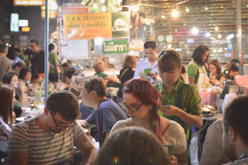 De toeristen genieten van het straatvoedsel bij de nachtmarkt in Chinatown, royalty-vrije stock afbeelding De toeristen genieten van het straatvoedsel bij de nachtmarkt in Chinatown, royalty-vrije stock afbeelding
