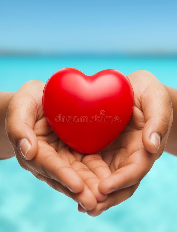 People, relationship and love concept - close up of womans cupped hands showing red heart. People, relationship and love concept - close up of womans cupped hands showing red heart