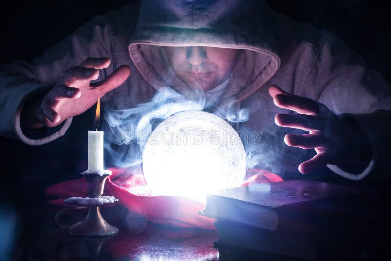 This captivating close-up image transports us into the realm of ancient magic and mysticism, as a wizard donning a white hood harnesses the power of a smoke-filled crystal ball on a desk adorned with a flickering candle in a candlestick and a collection of weathered old books. The scene is bathed in an air of intrigue and mystery, as the wizard predicts the future by gazing into the mystical depths of the crystal ball. The selective focus draws our attention to the intricate details of the crystal ball, capturing the ethereal wisps of smoke and the subtle reflections of light within. The soft glow of the candle casts enchanting shadows, heightening the sense of anticipation and conjuring an atmosphere of magical possibilities. With a hand suspended above the tools of divination, the wizard exudes an air of authority and mastery over the mystical arts. The presence of the old books signifies ancient wisdom and esoteric knowledge, suggesting a deep connection to the secrets of the universe and the power to unravel the mysteries of fate. This image is ideal for evoking the enchantment and wonder of mystical storytelling, making it suitable for book covers, editorial pieces, or promotional material related to magic, sorcery, and divination. It sparks the imagination and invites viewers to embark on a journey of discovery and revelation. This captivating close-up image transports us into the realm of ancient magic and mysticism, as a wizard donning a white hood harnesses the power of a smoke-filled crystal ball on a desk adorned with a flickering candle in a candlestick and a collection of weathered old books. The scene is bathed in an air of intrigue and mystery, as the wizard predicts the future by gazing into the mystical depths of the crystal ball. The selective focus draws our attention to the intricate details of the crystal ball, capturing the ethereal wisps of smoke and the subtle reflections of light within. The soft glow of the candle casts enchanting shadows, heightening the sense of anticipation and conjuring an atmosphere of magical possibilities. With a hand suspended above the tools of divination, the wizard exudes an air of authority and mastery over the mystical arts. The presence of the old books signifies ancient wisdom and esoteric knowledge, suggesting a deep connection to the secrets of the universe and the power to unravel the mysteries of fate. This image is ideal for evoking the enchantment and wonder of mystical storytelling, making it suitable for book covers, editorial pieces, or promotional material related to magic, sorcery, and divination. It sparks the imagination and invites viewers to embark on a journey of discovery and revelation.