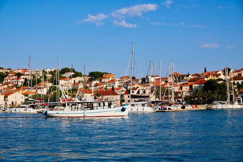 A traditional white wooden gullet style boat in the Split Harbour, Croatia, with blue sky and sea water. A traditional white wooden gullet style boat in the Split Harbour, Croatia, with blue sky and sea water.