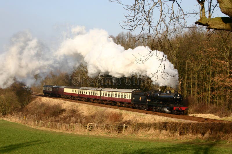 De Trein van de stoom in het Engelse platteland stock foto De Trein van de stoom in het Engelse platteland stock foto