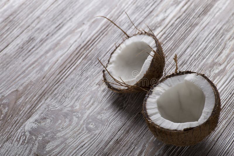 De twee helften van kokosnoot op een houten raad royalty-vrije stock afbeelding De twee helften van kokosnoot op een houten raad royalty-vrije stock afbeelding