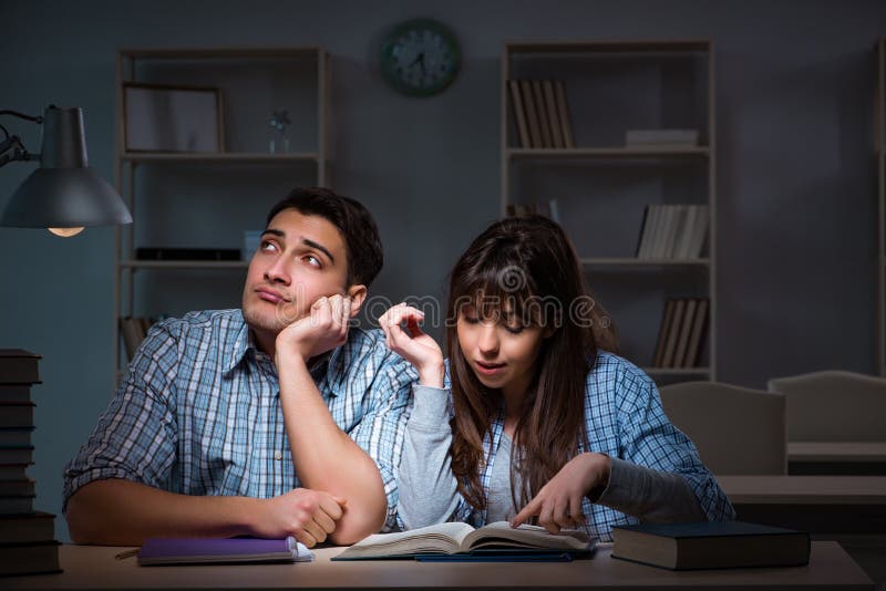 De twee studenten die laat bij nacht bestuderen royalty-vrije stock foto De twee studenten die laat bij nacht bestuderen royalty-vrije stock foto
