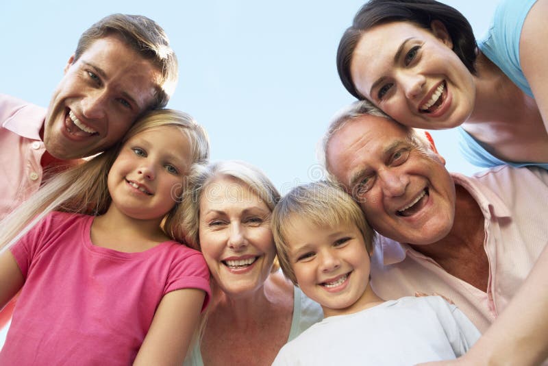 De uitgebreide Groep die van de Familie neer in Camera kijkt stock fotografie De uitgebreide Groep die van de Familie neer in Camera kijkt stock fotografie