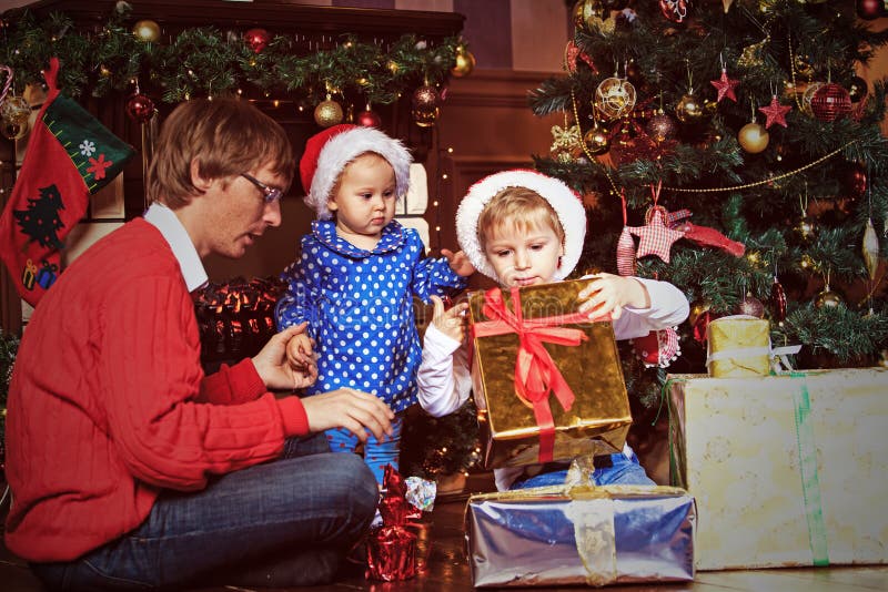 De vader en de jonge geitjes met stellen in Kerstmis voor stock afbeeldingen De vader en de jonge geitjes met stellen in Kerstmis voor stock afbeeldingen