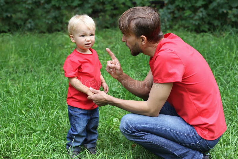 Father emotionally talks with a frustrated child. Upset toddler and his dad. Parenting difficulties concept. Family look clothing. Copy space. Father emotionally talks with a frustrated child. Upset toddler and his dad. Parenting difficulties concept. Family look clothing. Copy space.