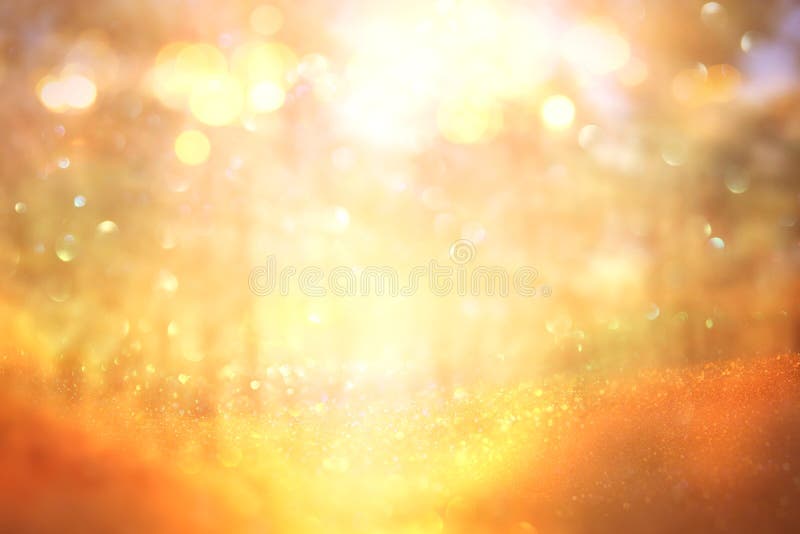 De vage abstracte foto van licht barstte onder bomen en schittert gouden bokehlichten