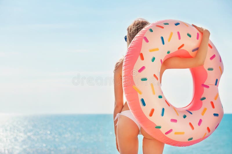 De vakantie van de zomer Het genieten van bruine kleur van vrouw in witte bikini met doughnutmatras dichtbij het zwembad royalty-vrije stock foto De vakantie van de zomer Het genieten van bruine kleur van vrouw in witte bikini met doughnutmatras dichtbij het zwembad royalty-vrije stock foto