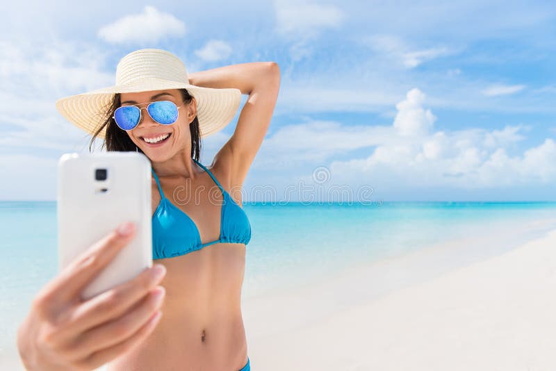 De vakantiemeisje die van het de zomerstrand prettelefoon nemen selfie stock afbeeldingen De vakantiemeisje die van het de zomerstrand prettelefoon nemen selfie stock afbeeldingen