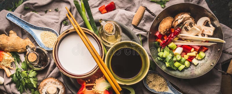 De vegetariër beweegt gebraden gerechtingrediënten: gehakte groenten, kruiden, kokosmelk, sojasaus, wok en eetstokjes, hoogste me