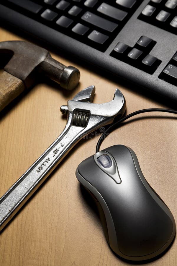 Metallic computer mouse, old tools placed next to compute keyboard. Metallic computer mouse, old tools placed next to compute keyboard