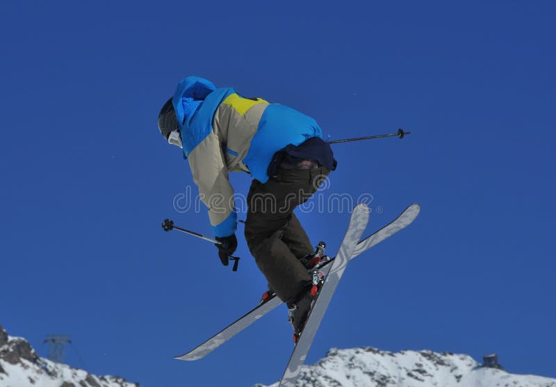 Freestyle ski jumper performing a full spin high in the air. Freestyle ski jumper performing a full spin high in the air