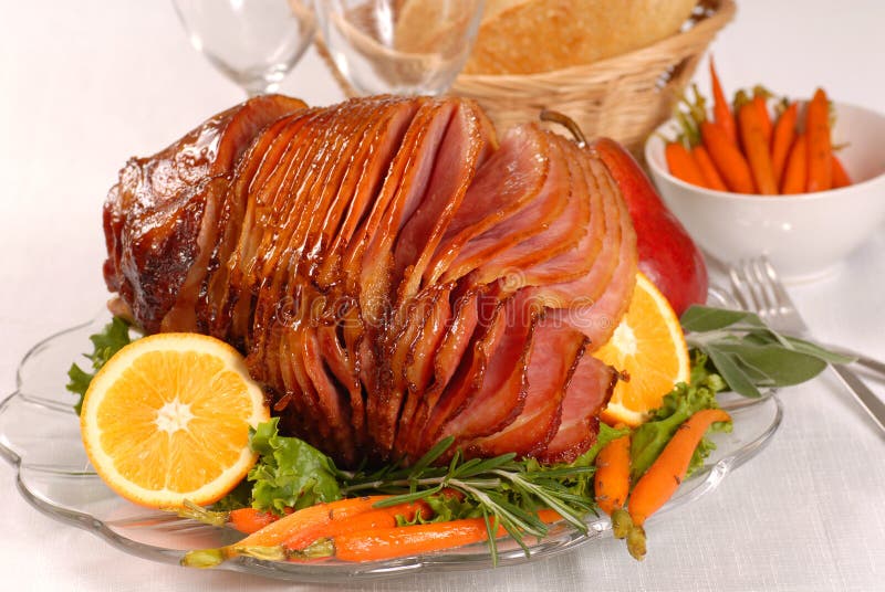 Brown sugar and honey glazed ham with carrots, herbs, fruit and bread. Brown sugar and honey glazed ham with carrots, herbs, fruit and bread