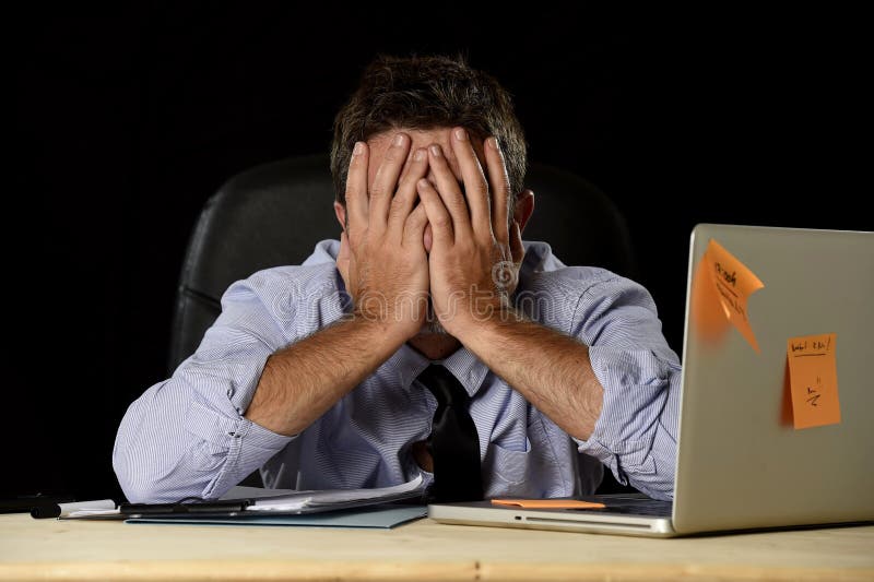 De vermoeide zakenman die het werk aan spanning lijden verspilde ongerust gemaakte bezig in bureau laat bij nacht met laptop comp stock afbeelding De vermoeide zakenman die het werk aan spanning lijden verspilde ongerust gemaakte bezig in bureau laat bij nacht met laptop comp stock afbeelding