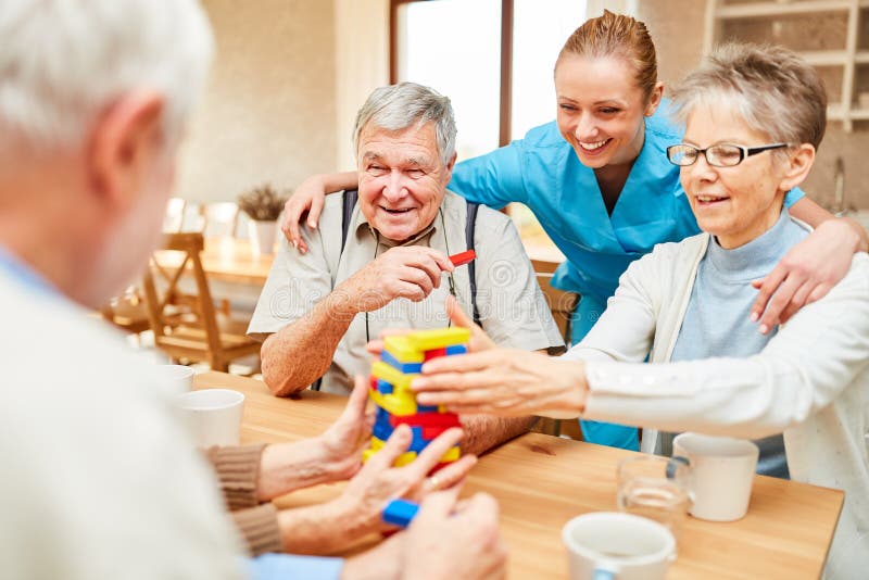 Nursing home care in demente seniors while playing with building blocks. Nursing home care in demente seniors while playing with building blocks