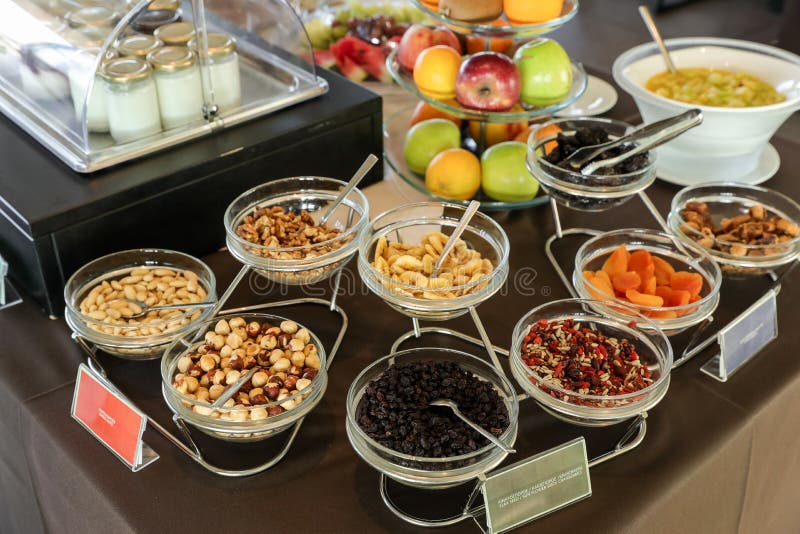 De verscheidenheid van droge noten en de bessen voor gezond ontbijtbuffet dienen ook sommige vruchten en yoghurts in Grieks hotel