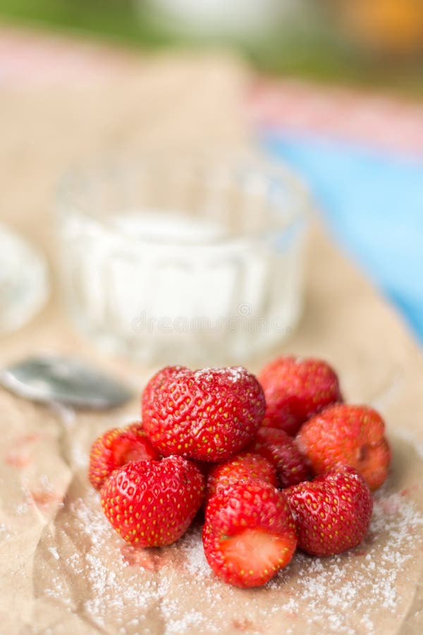 De verse aardbeien met suiker en suiker werpen op het gerimpelde bruine pakdocument stock afbeelding De verse aardbeien met suiker en suiker werpen op het gerimpelde bruine pakdocument stock afbeelding
