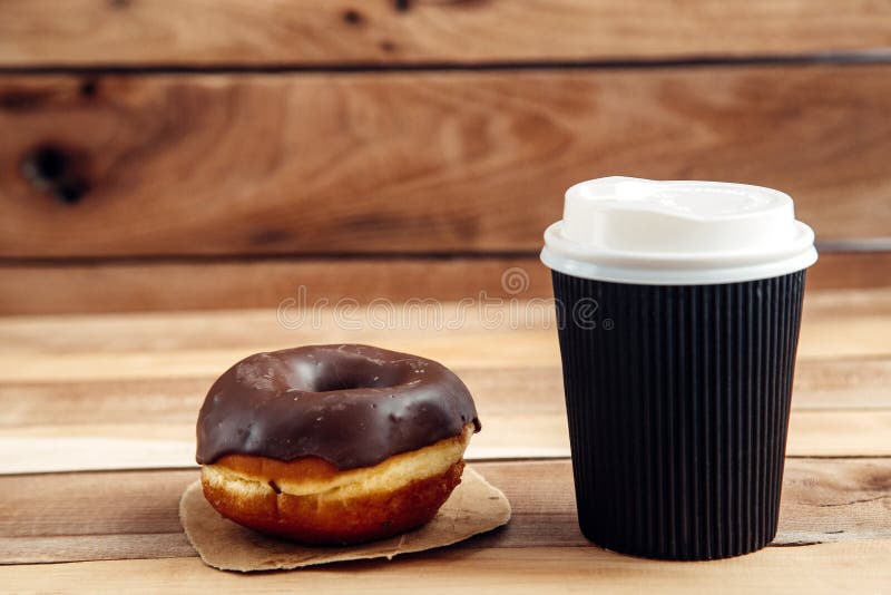De verse artisanale doughnut en haalt koffie, houten achtergrond met exemplaarruimte weg royalty-vrije stock afbeeldingen De verse artisanale doughnut en haalt koffie, houten achtergrond met exemplaarruimte weg royalty-vrije stock afbeeldingen