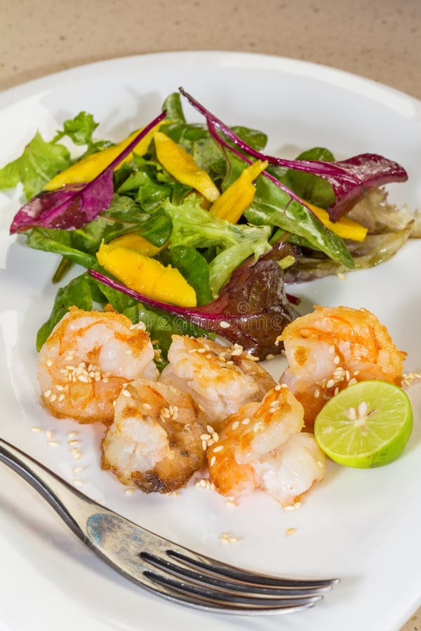 De verse salade met gebraden garnalen, verscheidenheid van salade doorbladert, mango, o stock afbeeldingen De verse salade met gebraden garnalen, verscheidenheid van salade doorbladert, mango, o stock afbeeldingen