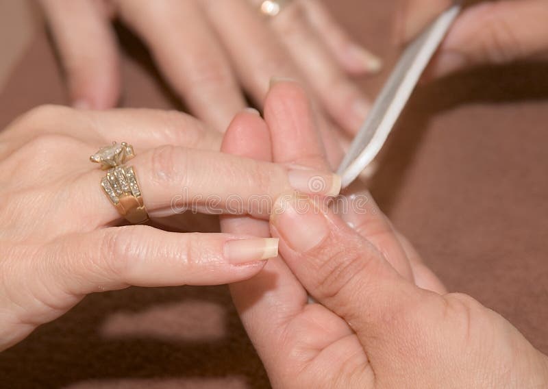 Fingernails of pampered hands are filed into shape. Fingernails of pampered hands are filed into shape