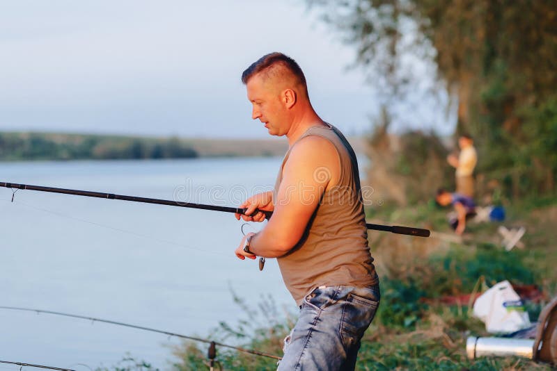 De visser bereidt breuk voor het vangen van karper bij meer in de zomer voor royalty-vrije stock foto De visser bereidt breuk voor het vangen van karper bij meer in de zomer voor royalty-vrije stock foto