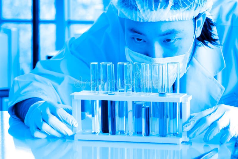 De vloeibare substantie controleerde door Aziatische wetenschapper of chemicus bij laboratorium stock afbeelding De vloeibare substantie controleerde door Aziatische wetenschapper of chemicus bij laboratorium stock afbeelding