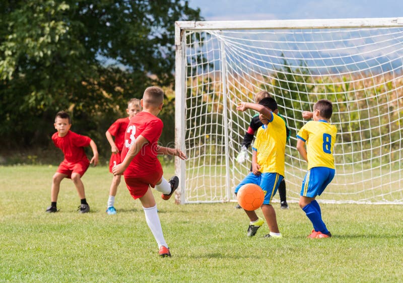 De voetbal van het jonge geitjesvoetbal - de gelijke van kinderenspelers op voetbalgebied royalty-vrije stock afbeelding De voetbal van het jonge geitjesvoetbal - de gelijke van kinderenspelers op voetbalgebied royalty-vrije stock afbeelding