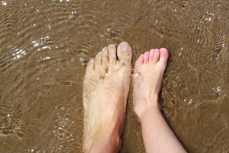 De voeten van de vader en van kinderen op het strand van het de zomerzand stock foto De voeten van de vader en van kinderen op het strand van het de zomerzand stock foto