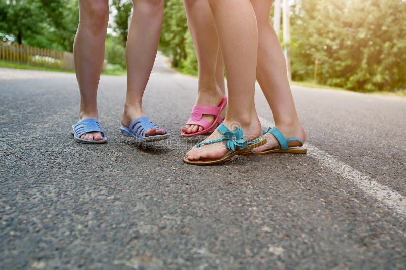 De voeten van kinderen in Pantoffels op het asfalt stock foto De voeten van kinderen in Pantoffels op het asfalt stock foto